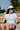 Woman wearing the Classic Cowboy Landry white and navy corduroy snapback at a tailgate.