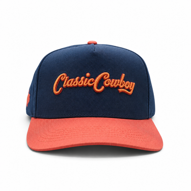 Classic Cowboy The Wildcatter navy and coral snapback with coral script embroidery, front view.