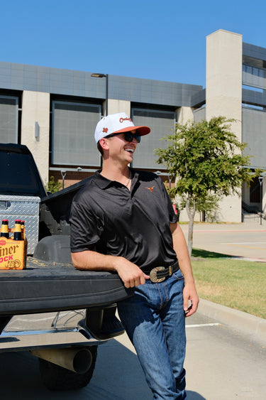 Man wearing the Classic Cowboy Capitol white and rust snapback at a tailgate.