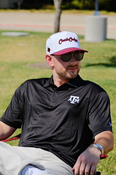 Man wearing the Classic Cowboy Brazos white and maroon snapback outdoors.