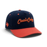 Classic Cowboy The Wildcatter navy and coral snapback with Texas side embroidery, angled view.