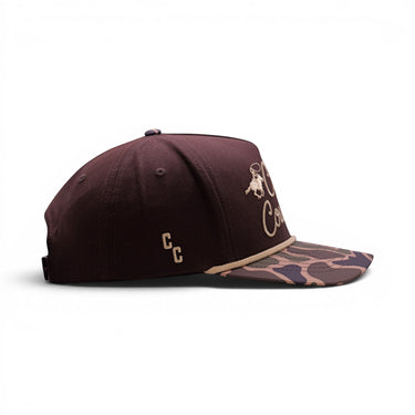 Classic Cowboy The Vaquero brown baseball cap with camouflage brim and embroidered logo.